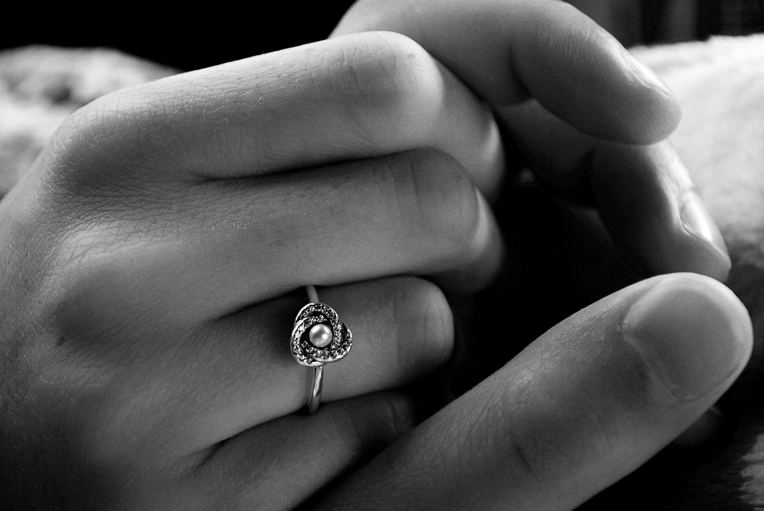 Close-up of a pearl and diamond engagement ring on a bride’s hand.