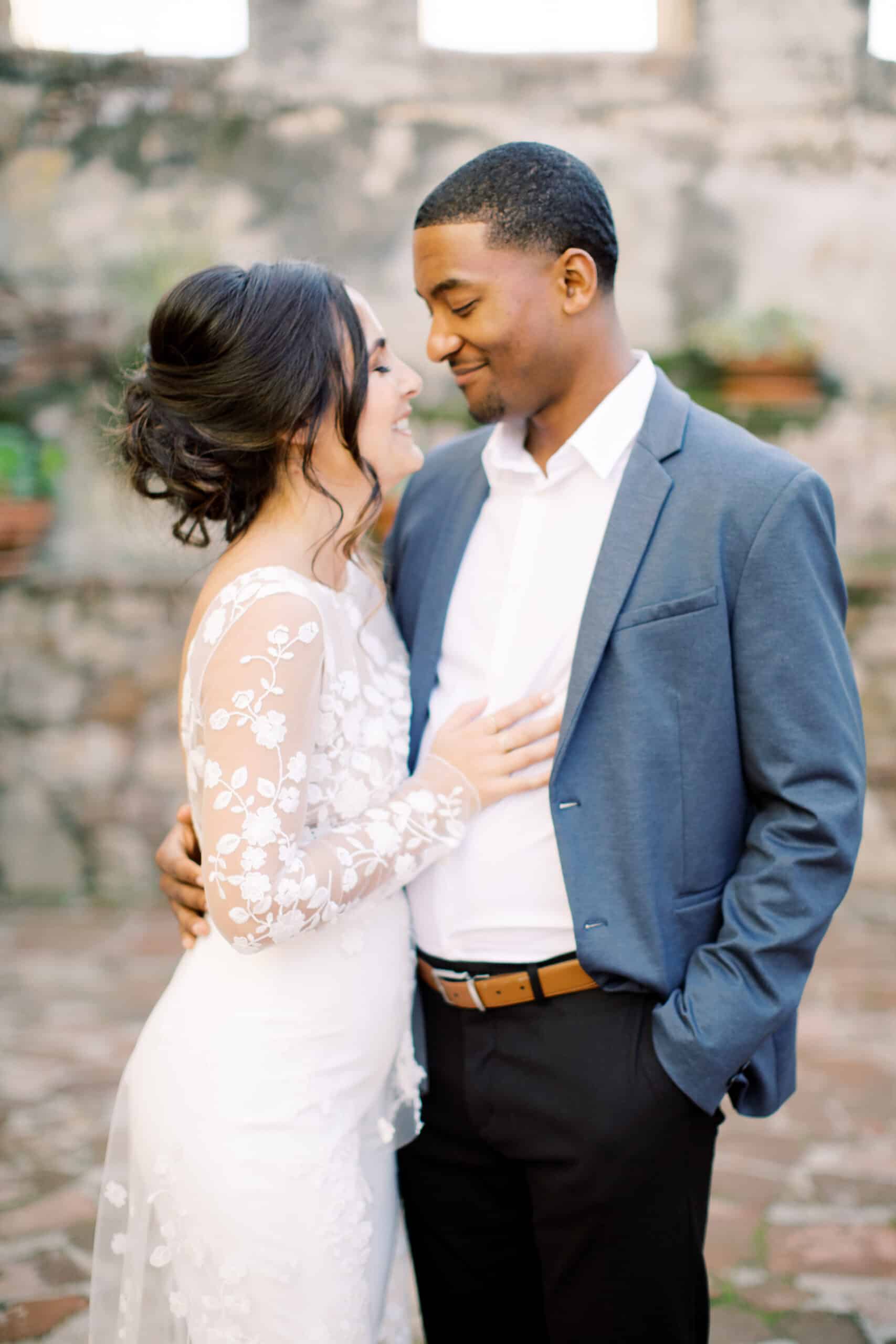 Elegant wedding couple portrait in rustic outdoor setting. Romantic couple embracing at wedding, natural background and soft lighting.