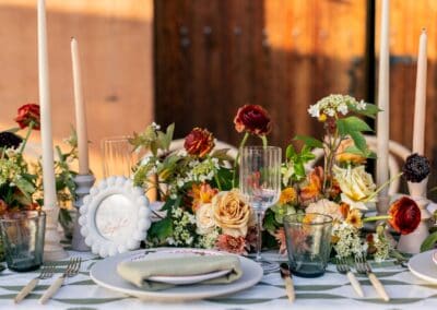Beautiful outdoor wedding table setup with floral arrangements and candles for a romantic event.