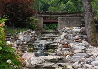 Beautiful garden wedding venue featuring a peaceful stream and rustic bridge.